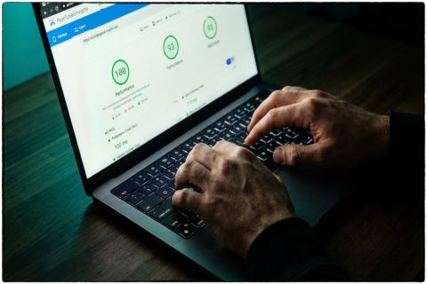 Développeur consultant un rapport Google PageSpeed Insights avec des scores de performance élevés en vert sur laptop